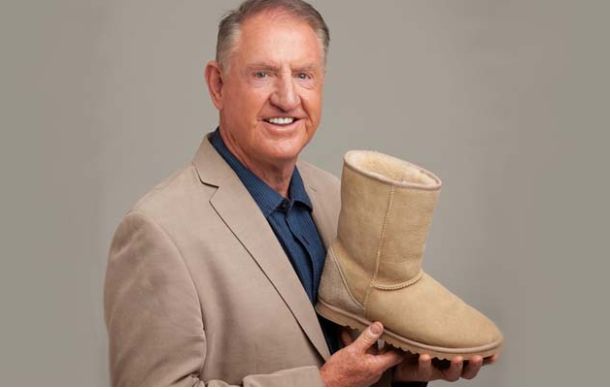 Brian Smith, founder of UGG, holding one of the original sheepskin boots